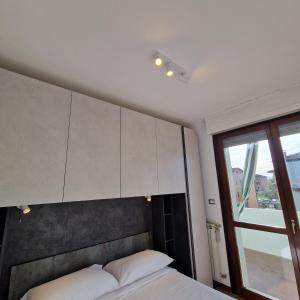a bedroom with a bed with white cabinets and a window at Appartamento King a Gattatico Centro in Praticello di Gattatico