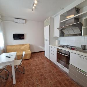 a kitchen with white cabinets and a table and a stove at Appartamento King a Gattatico Centro in Praticello di Gattatico