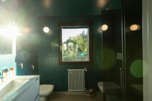 a bathroom with a sink and a toilet and a window at Isola Degli Angeli in Figline Valdarno