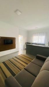 a living room with a couch and a flat screen tv at Kitnet tipo Apartamento Mobiliado em Itu para até 6 pessoas Temporada in Itu