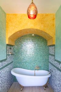 Gioiellaにある16th Century Townhouse, Large Garden Near Lake, Tuscany and Umbria - Sleeps 18の緑のタイル張りのバスルーム(バスタブ付)