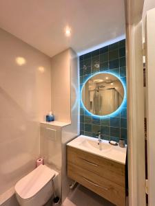 a bathroom with a sink and a toilet and a mirror at Vue Odet - calme & lit Queen Size à Quimper in Quimper