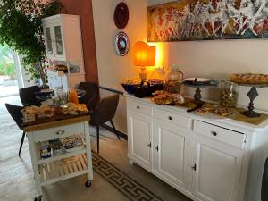 a kitchen with white cabinets and a table with food on it at Blu Oltremare camere bijoux in Varazze +138 photos