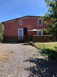 a red building with an umbrella in front of it at House 2 people in Castaignos-Souslens