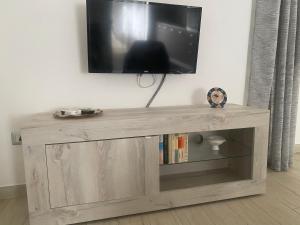 a wooden entertainment center with a television on a wall at La Dolce Sosta in Luras +3 photos