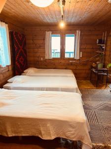 1 dormitorio con 3 camas en una cabaña de madera en 海を眺めるログハウス カマカーマAwaji, en Awaji