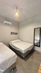 a bedroom with two beds and a light fixture at Suite Cajueiro in Barrinha