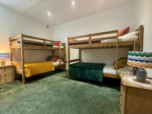 EythorneにあるWisteria Lodge, beautiful home in a great locationの緑のカーペットが敷かれた部屋に二段ベッドが2つ