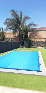Una gran piscina azul en un patio. en Durbanville Luxury Living Private Room, en Durbanville