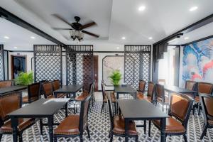 a restaurant with tables and chairs and a ceiling fan at Cozy An Luangprabang Hotel in Luang Prabang
