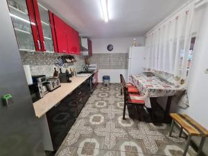 a kitchen with red cabinets and a table with chairs at ingrid in Mangalia
