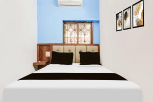 a bedroom with a bed with blue walls and a window at Hotel O KPN Holiday Homes in Goa