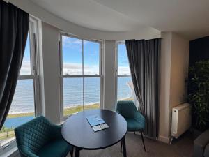a room with a table and chairs and a view of the ocean at The Marlborough Sea View Holiday Apartments in Scarborough