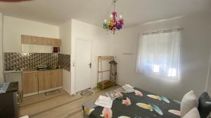 a kitchen with a bed in a room with a chandelier at PAGONI apartments 2 in Kardamaina