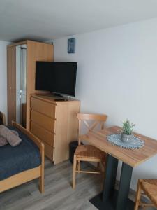 a living room with a table and a tv at Pension Ambiente in Mühlberg
