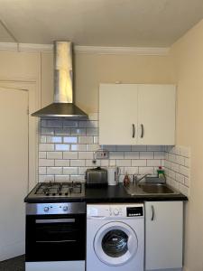 a kitchen with a stove and a washing machine at Entire Peaceful in Central London in London