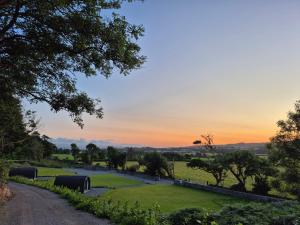 a sunset over a park with a river and trees at Culdaff Estate Glamping in Culdaff