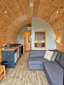 a living room with a couch and a kitchen at Culdaff Estate Glamping in Culdaff