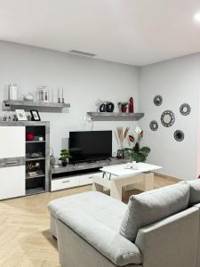 a living room with a couch and a tv at Casa en Villa Romero in Alora