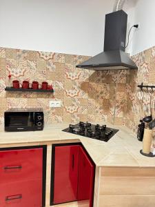 a kitchen with red cabinets and a stove top oven at Casa en Villa Romero in Alora +13 photos