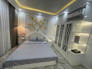 a bedroom with a bed and a wall with flowers at Happy Hou'se in Cat Ba