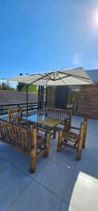 two wooden benches sitting under an umbrella at Dava&Davi in Ureki