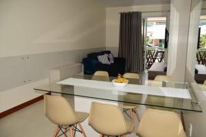 a living room with a glass table and chairs at Apartamento a beira mar completo com churrasqueira in Florianópolis