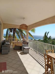 a patio with a view of the ocean at Leu doux bruit des vagues in Saint-Leu
