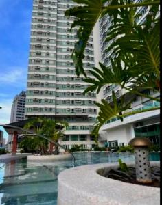 a large apartment building with a pool in front of a building at My Quiet Place at The Beacon - Makati City in Manila