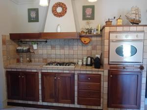 a kitchen with a stove and a microwave at Un sorriso sul Viso in Martiniana Po