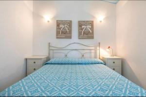 a bedroom with a blue bed with two night stands at Villino Mimosa in Costa Rei