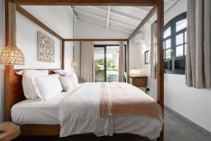 a bedroom with a large white bed and a window at Villa Karibu in Les Trois-Îlets +47 photos