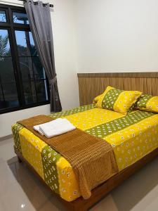 a bedroom with a yellow bed with polka dots at Majid's Homestay Solo in Kartosuro