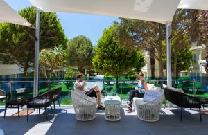 a group of people sitting in chairs on a patio at Flora Garden Ephesus Kusadasi - All Inclusive in Davutlar