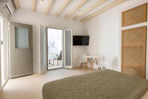 a bedroom with a bed and a table with chairs at Cycladic Suites in Naousa