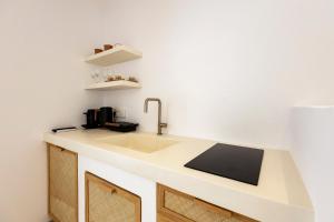 a kitchen with a sink and a counter top at Cycladic Suites in Naousa