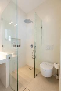 a bathroom with a toilet and a glass shower at Cycladic Suites in Naousa +17 photos