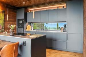 a kitchen with gray cabinets and a sink at Villa Pikku Karhu in Kuusamo
