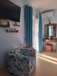 a living room with a chair and a flat screen tv at Actis studios 2 in Stelida