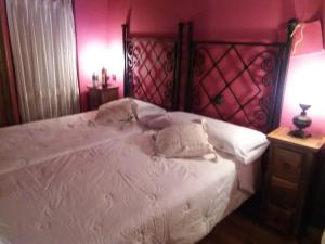 a bedroom with a large white bed with pink walls at Carpe Diem in Navaridas