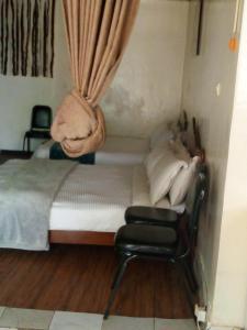 a small bedroom with a bed and a chair at DV Guest House in Addis Ababa