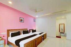 1 dormitorio con 1 cama grande y pared de color rosa en Super Hotel O SRI NIRVANA PLAZA, en Gachibowli