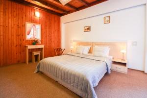 a bedroom with a large bed and a desk at Hotel Roberto Sinaia in Sinaia