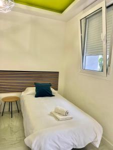 a bedroom with a white bed with a window at La Villa del Sastre in Vélez-Málaga