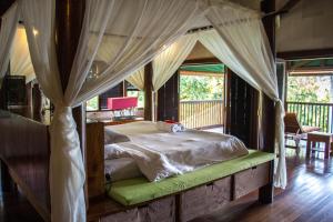 a bedroom with a canopy bed with a porch at Luxurious Private Holiday Villa at Tip of Borneo in Kudat