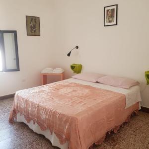 a bedroom with a bed with a pink blanket on it at Casavacanze Salento Sole in Veglie