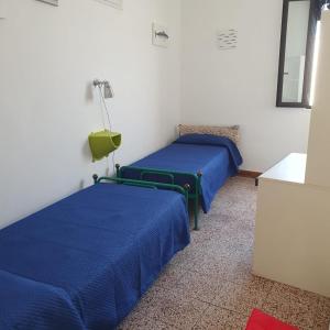 two beds in a room with blue sheets at Casavacanze Salento Sole in Veglie