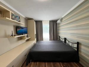 a small bedroom with a bed and a tv at Seven Apartments 62 in Vyshneve