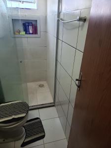 a bathroom with a shower with a toilet and a glass door at ApartamentoA306 in Ananindeua