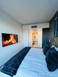 a bedroom with a large bed with a tv on the wall at Sandton Pool View with Balcony in Johannesburg